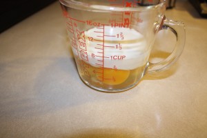 three eggs and cream in a measuring cup