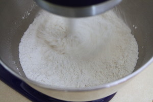 The grains of kosher salt won't fit through the sifter, so you need to mix them in with the flour.