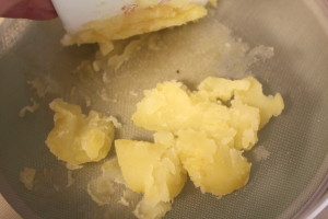 pressing potatoes through a tamis