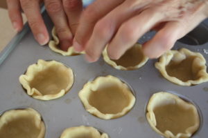 fitting crust into muffin tins